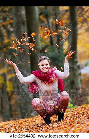 Stock Image - Stock Photo - Teenager is playful with Autumn leaves. Fotosearch