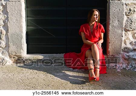 Stock Photography - Stock Photo - Young woman in long Red dress sidelighted. Fotosearch