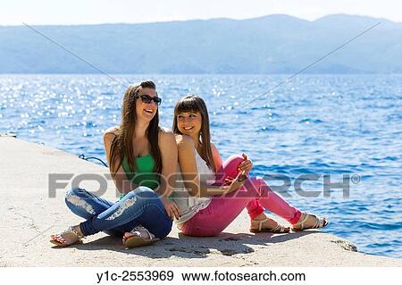 Stock Photo - Teen girlfriends under strong midday sun. Fotosearch