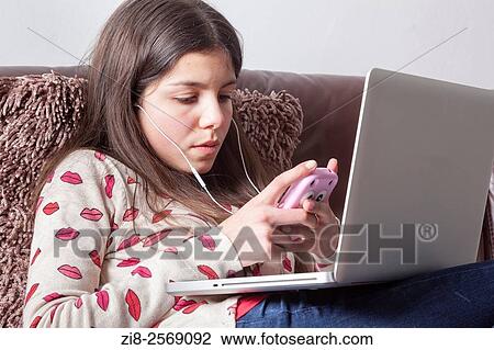 Stock Image - Teenage girl, 12-13, on chatting on computer.. Fotosearch