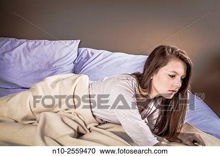 Stock Image - Teenage girl on her bed.. Fotosearch