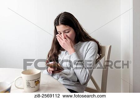 Teenage girl reading on mobile phone, looking embarrassed. View Large Photo Image Stock Image - Teenage girl reading on mobile phone, looking embarrassed.. Fotosearch