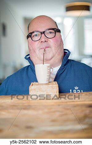 Tilburg, Netherlands. Middle-aged man with muscular dystrophy and dependend on a wheelchair, drinking his coffee through a straw. View Large Photo Image Stock Image - Tilburg, Netherlands. Middle-aged man with muscular dystrophy and dependend on a wheelchair, drinking his coffee through a straw.. Fotosearch