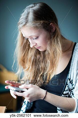 Tilburg, Netherlands. Young, attractive woman reading messages on her smartphone. View Large Photo Image Stock Image - Tilburg, Netherlands. Young, attractive woman reading messages on her smartphone.. Fotosearch