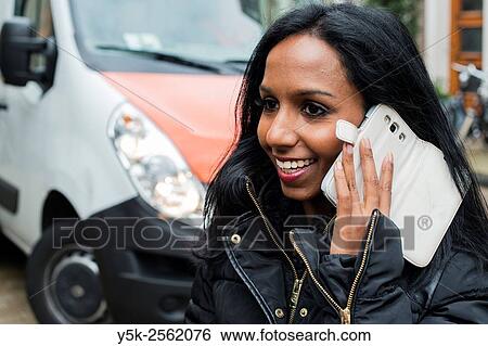 Tilburg, Netherlands. Young, attractive female having a conversation in the streets, using her smartphone. View Large Photo Image Stock Photograph - Tilburg, Netherlands. Young, attractive female having a conversation in the streets, using her smartphone.. Fotosearch