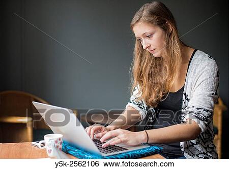 Tilburg, Netherlands. Young, attractive woman at home working behind her notebook computer. View Large Photo Image Stock Photograph - Tilburg, Netherlands. Young, attractive woman at home working behind her notebook computer.. Fotosearch