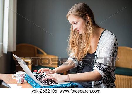 Tilburg, Netherlands. Young, attractive woman at home working behind her notebook computer. View Large Photo Image Stock Photography - Tilburg, Netherlands. Young, attractive woman at home working behind her notebook computer.. Fotosearch