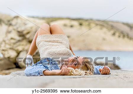 Stock Photography - Top down lying on back attractive young woman.. Fotosearch