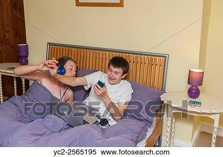Two brothers winding each other up when having to share a bed on holiday. View Large Photo Image Stock Photography - Two brothers winding each other up when having to share a bed on holiday.. Fotosearch
