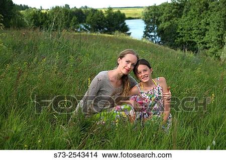 Picture - Woman and daughter in the grass, Kirillovka, Togliatti, Samara Region, Russia. Fotosearch