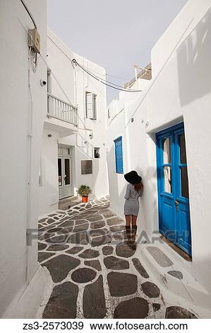 Woman in the alleys of town center, Mykonos, Cyclades Islands, Greek Islands, Greece, Europe. View Large Photo Image Stock Photo - Woman in the alleys of town center, Mykonos, Cyclades Islands, Greek Islands, Greece, Europe.. Fotosearch
