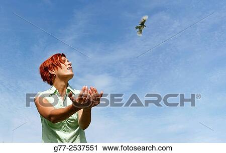 Woman releasing a bird. Budapest, Hungary View Large Photo Image Stock Image - Woman releasing a bird. Budapest, Hungary. Fotosearch