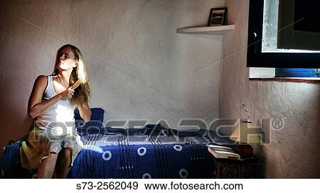 Woman sitting on bed brushing long blonde hair View Large Photo Image Stock Photo - Woman sitting on bed brushing long blonde hair. Fotosearch