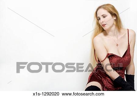 Woman with long blond hair and fair skin sits on the floor wearing a short red dress with straps but one shoulder is exposed. View Large Photo Image Stock Image - Woman with long blond hair and fair skin sits on the floor wearing a short red dress with straps but one shoulder is exposed.. Fotosearch