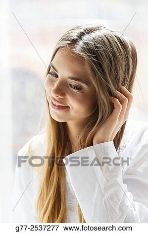 Young caucasian woman touching her hair View Large Photo Image Stock Photo - Young caucasian woman touching her hair. Fotosearch