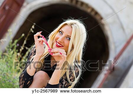 Stock Photo - Young lady brushing her nails with abrasive pad. Fotosearch