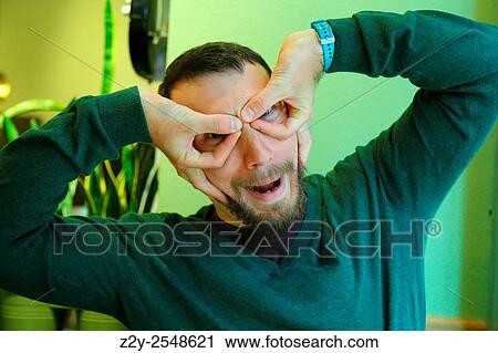 Young man with his hands on his face as a mask. View Large Photo Image Stock Image - Young man with his hands on his face as a mask.. Fotosearch