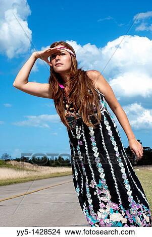 Picture - Young woman has a black dress, made a hand signal.. Fotosearch