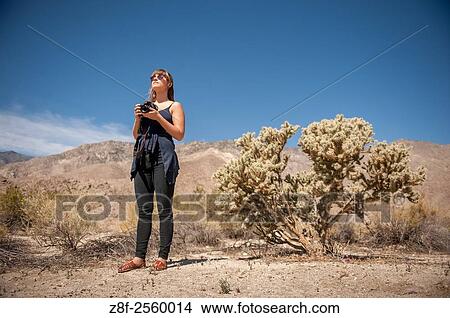 Young woman holding camera near Palm Springs, California. View Large Photo Image Picture - Young woman holding camera near Palm Springs, California.. Fotosearch