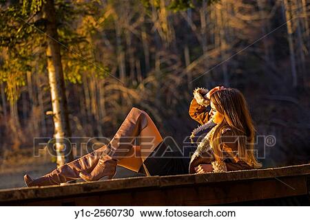 Stock Image - Young woman in short dress and boots. Fotosearch