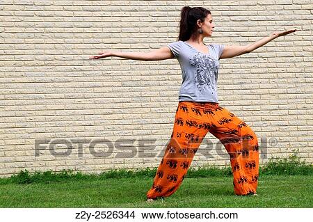 Picture - Young woman practicing tai-chi outdoor.. Fotosearch