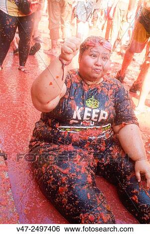 Stock Photograph - 150 tons of tomatoes serve as ammunition for traditional Tomatina, a battle which attracted this year more than 22, 000 people of 96 different nationalities to launch a record number tomatoes. Buñol, Valencia province, Spain.. Fotosearch