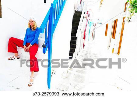 Stock Image - 30 year old woman in a Mykonos street, Cyclades Islands, Greece, Europe. Fotosearch