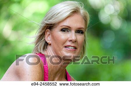 56 year old blond woman smiling at the camera, outdoors. View Large Photo Image Stock Image - 56 year old blond woman smiling at the camera, outdoors.. Fotosearch