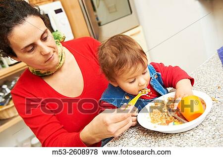 A caucasian mother feeding her eight months old baby girl. View Large Photo Image Stock Photo - A caucasian mother feeding her eight months old baby girl.. Fotosearch