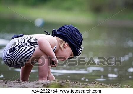 A female toddler in a swimming suit at Fish Lake, Spokane, Washington, USA. View Large Photo Image Picture - A female toddler in a swimming suit at Fish Lake, Spokane, Washington, USA.. Fotosearch