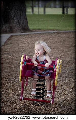 A female toddler plays on a toy at a park in Spokane, Washington, USA. View Large Photo Image Stock Image - A female toddler plays on a toy at a park in Spokane, Washington, USA.. Fotosearch