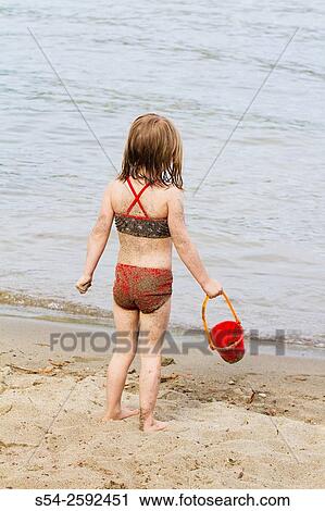 A four-year-old girl plays on the beach at Liberty Lake, Washington, USA. View Large Photo Image Stock Image - A four-year-old girl plays on the beach at Liberty Lake, Washington, USA.. Fotosearch