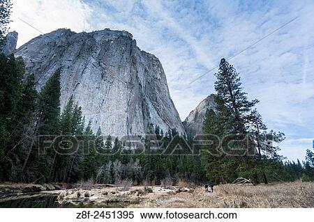 A landscape view of a rocky mountain, trees, and a river below, at Yosemite National Park, California, USA. View Large Photo Image Stock Photography - A landscape view of a rocky mountain, trees, and a river below, at Yosemite National Park, California, USA.. Fotosearch