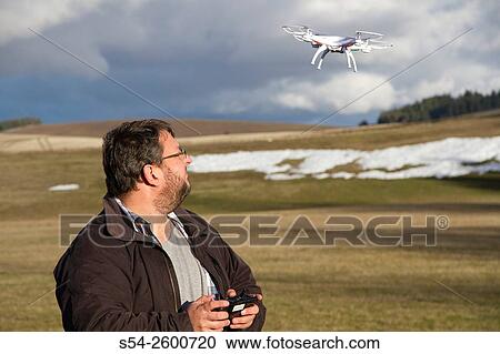 A man flying a small drone outdoors in Spokane county, USA. View Large Photo Image Stock Image - A man flying a small drone outdoors in Spokane county, USA.. Fotosearch