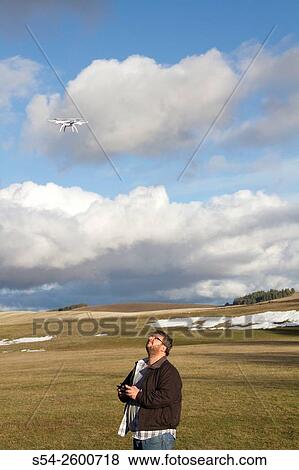 A man flying a small drone outdoors in Spokane county, USA. View Large Photo Image Stock Photo - A man flying a small drone outdoors in Spokane county, USA.. Fotosearch