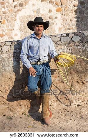 Stock Image - A Mexican charro or cowboy practices roping skills on his horse before a Charreada competition at a hacienda ranch in Alcocer, Mexico.. Fotosearch
