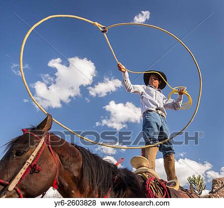Stock Photo - A Mexican charro or cowboy practices roping skills on his horse before a Charreada competition at a hacienda ranch in Alcocer, Mexico. Fotosearch
