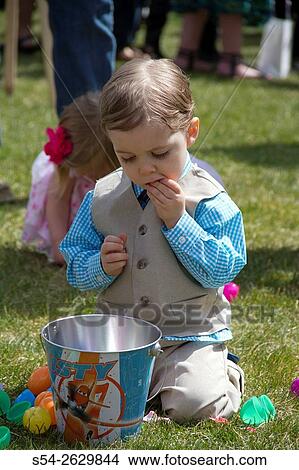 Picture - A young boy eats candy after an Easter egg hunt in Pullman, Washington, USA.. Fotosearch