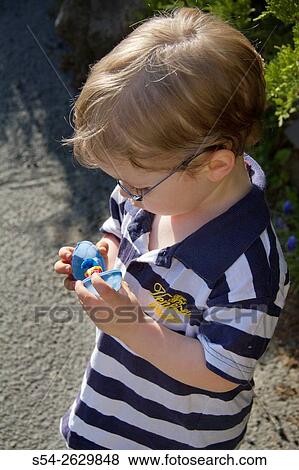 A young boy inspecting his Easter candy after a hunt. View Large Photo Image Stock Photo - A young boy inspecting his Easter candy after a hunt.. Fotosearch