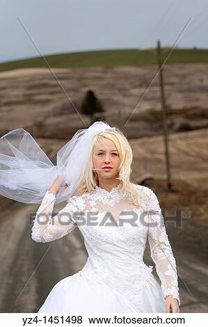 A young bride outdoors wearing her wedding dress. View Large Photo Image Stock Photo - A young bride outdoors wearing her wedding dress.. Fotosearch