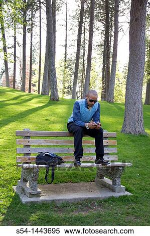 A young businessman sits on a park bench in Spokane, Washington, USA. View Large Photo Image Stock Photography - A young businessman sits on a park bench in Spokane, Washington, USA.. Fotosearch