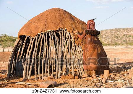 A young Himba covers your future home with mud, the structure structure is performed by men while women are responsible for covering it. View Large Photo Image Stock Image - A young Himba covers your future home with mud, the structure structure is performed by men while women are responsible for covering it.. Fotosearch