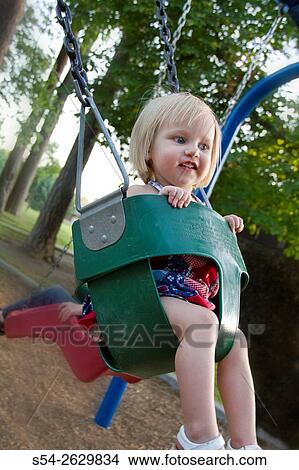 Picture - A young toddler in a swing at the park in Spokane, Washington, USA.. Fotosearch