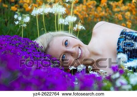 A young woman of caucasian ethnicity outdoors in a garden. View Large Photo Image Picture - A young woman of caucasian ethnicity outdoors in a garden.. Fotosearch