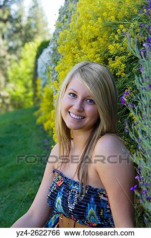 A young woman sitting outdoors at a park in Spokane, Washington, USA. View Large Photo Image Stock Photograph - A young woman sitting outdoors at a park in Spokane, Washington, USA.. Fotosearch