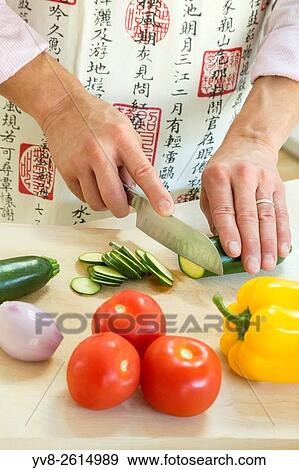 Adult male cutting food in the kitchen. View Large Photo Image Stock Photo - Adult male cutting food in the kitchen.. Fotosearch