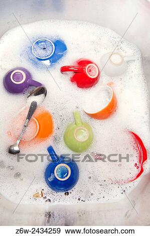 Stock Photo - After dinner coffee cups to be washed in the sink.. Fotosearch