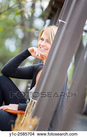 Picture - Attractive woman behind corner smiling at camera. Fotosearch