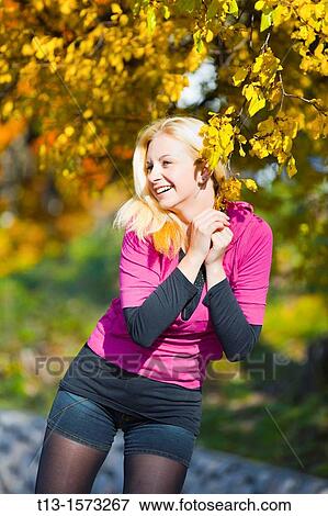 Stock Photo - Attractive young woman is happy in the Autumn. Fotosearch