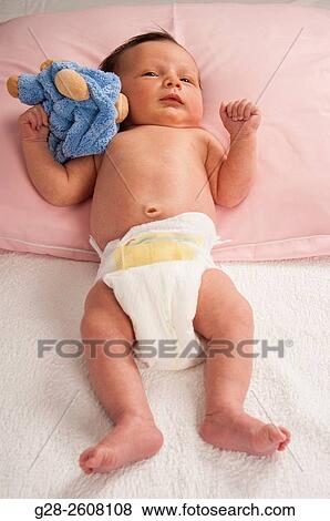 Stock Photo - Baby 2 weeks old with soft toy. Fotosearch